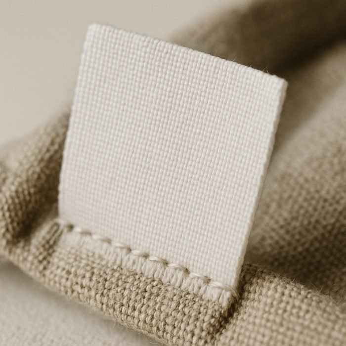 Extreme macro of a folded woven care label stitched into a garment seam